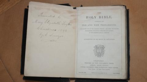 Open Bible with a handwritten note in the inside cover