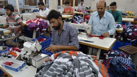 Men work in a garment factory in Ludhiana