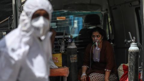 A woman receives oxygen outside an Indian hospital