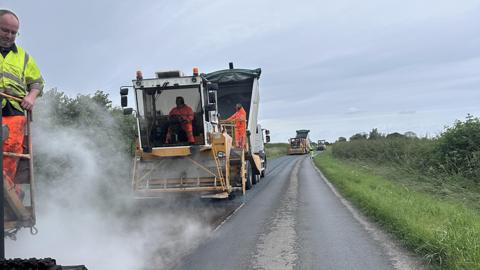 Chippings being laid on road
