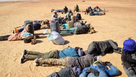 This photo from 2019 shows a group of migrant men resting before carrying on their journey across the Air dessert, northern Niger, towards the Libyan border