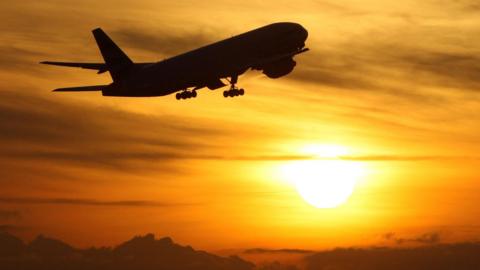 Plane taking off at sunset