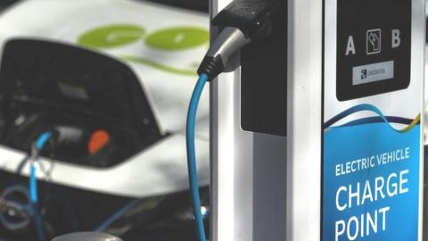 An electric car plugged into a public charge point