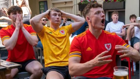 Football fans watch Wales v Switzerland at the Philharmonic pub in Cardiff city centre on 12 June