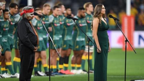 A musician sings the Australian national anthem