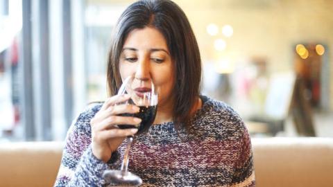 Woman drinking glass of red wine