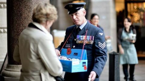Members of the armed forces sell poppies