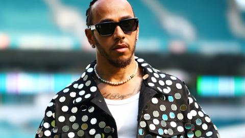 Lewis Hamilton arrives at Miami's Hard Rock Stadium wearing a mirrored suit