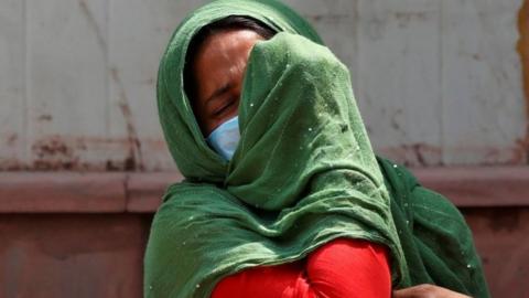 A woman mourns after her father died due to the coronavirus disease (COVID-19) outside a mortuary of a COVID-19 hospital in New Delhi, India, April 15, 2021.