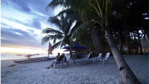 Tourist watch the sun set on the Philippine island of Boracay