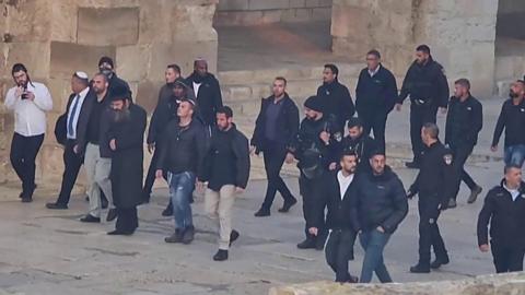 Israeli minister Itamar Ben-Gvir walking through Al-Aqsa plaza surrounded by security