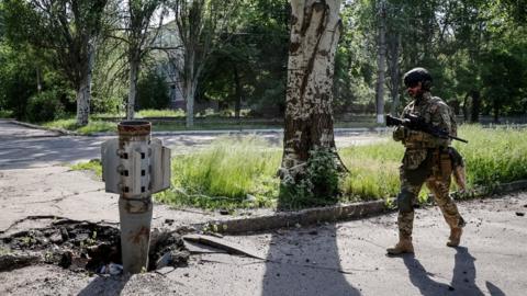 A Ukrainian serviceman walks near a shell of a multiple rocket launch system, as Russia"s attack on Ukraine continues, in Lysychansk, Luhansk region, Ukraine June 2, 2022.