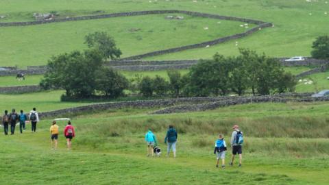 2020/08/01: A group of hikers climb down a hill on Hope Valley in the Peak district.
