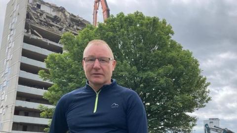 Councillor Ray Godwin in front of Anson and Hudson House which is being demolished