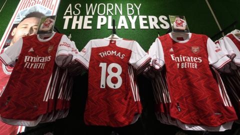 Arsenal shirts with Thomas Partey's name and number on hanging up for sale