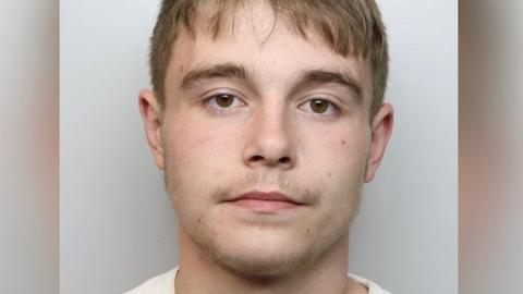 Young man with short hair in police mugshot