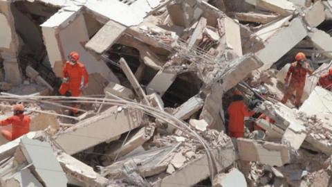 Rescuers search the rubble for missing residents