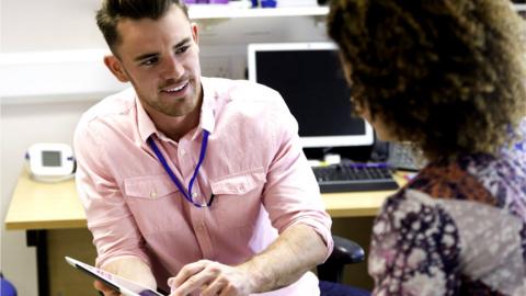 Young male doctor chatting to his patient