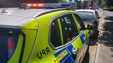 Police car pulling over silver car