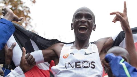 Eliud Kipchoge celebrates breaking the two-hour marathon barrier as he is held up on supporters' shoulders