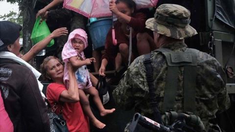 Soldiers assist villagers ride a truck as they are evacuated in anticipation of an approaching typhoon in Legaspi city, Albay province, Philippines, on 2 December 2019