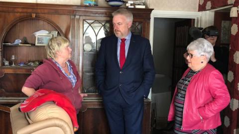 Carwyn Jones talking to two women in a flooded home