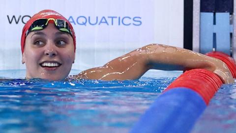 Freya Colbert smiles in the pool after winning gold at the World Championships