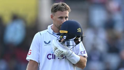 Joe Root kisses the badge of his England helmet to celebrate a century v India