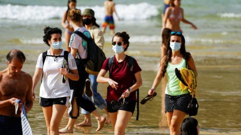 People wear masks at La Concha beach after Spain introduced stricter mask laws during the coronavirus disease (COVID-19) outbreak, in San Sebastian, Spain, March 31, 2021