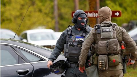 A soldier and police officer stand near the entrance of the Hoge Kempen National Park