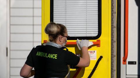 Ambulance worker cleans ambulance handrail