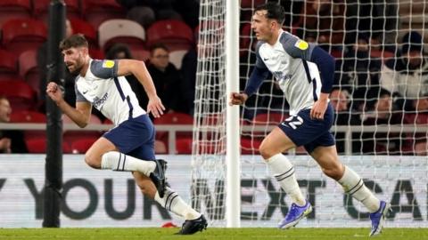 Ched Evans (left) wheels away after scoring for Preston