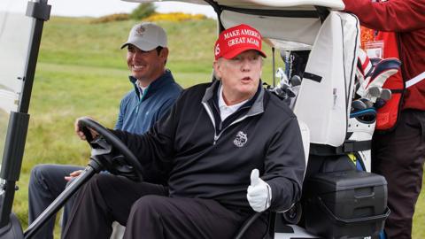 Donald Trump rides a golf buggy at his resort in Turnberry, Scotland