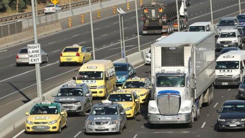 Taxi drivers drive slowly along Melbourne's Tullamarine Freeway