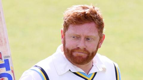 Jonny Bairstow raises his bat after dismissal