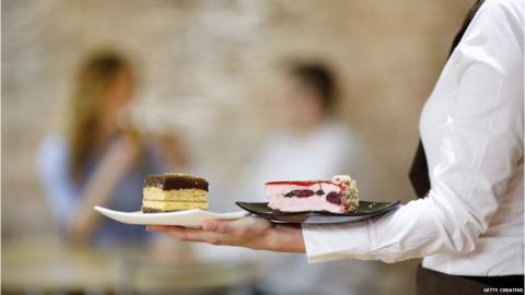 A waitress serves dessert