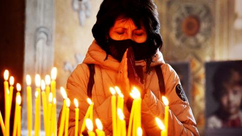 A woman prays at Church of the Holy Apostles Peter and Paul, in Lviv - 13 March 2022