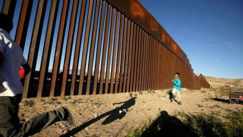 Children run along the border fence between Mexico and the United States during an inter-religious service against US President Donald Trump's border wall in Ciudad Juarez, Mexico, on 26 February 2019