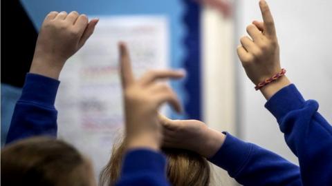 Pupils with hands in the air