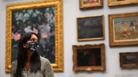 Gallery worker in face covering poses at Tate Britain ahead of its reopening