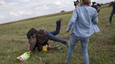 Hungarian camerawoman Petra Laszlo was filmed apparently kicking and tripping up migrants fleeing police, including a man carrying a child. Pictured in Roszke village, Hungary, September 8, 2015.