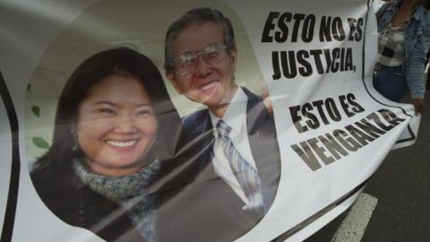 A supporter of Keiko Fujimori, opposition leader and daughter of disgraced ex-president Alberto Fujimori, holds a banner reading "This is not justice. This is revenge" outside a police facility in Lima on October 10, 20