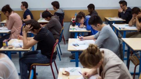 French students work on the test of philosophy as they take the baccalaureat exam (high school graduation exam) on June 17, 2013 at the Arago high school in Paris