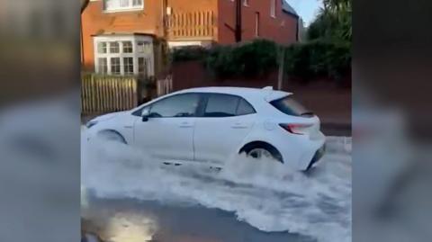 Car driving through floodwater