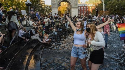 People stand in the fountain as they celebrate in Washington Square Park in New York City