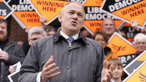 Liberal Democrat leader Sir Ed Davey stands in front of party supporters as he speaks to the media at the London Recreation Ground in Camberley, Surrey, on 22 May 2024 after a General Election was called for July 4.