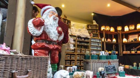 A Father Christmas ornament on a Christmas market stall