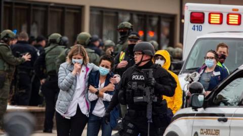 Healthcare workers walk out of a King Sooper's Grocery store after a gunman opened fire on 22 March 2021 in Boulder, Colorado