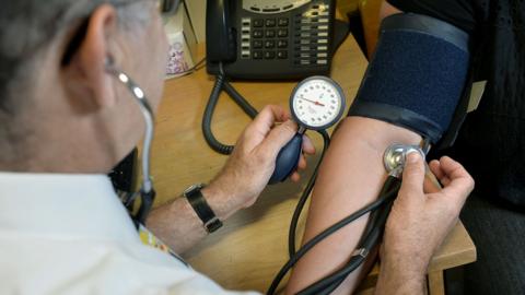 A GP measures the blood pressure of a patient