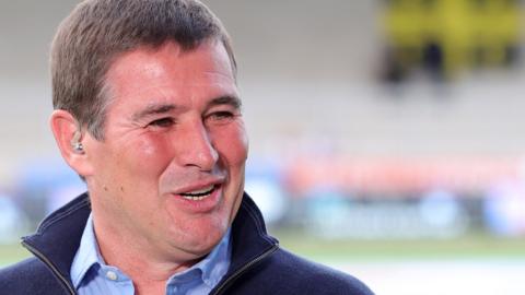 Nigel Clough smiles while talking on the sideline